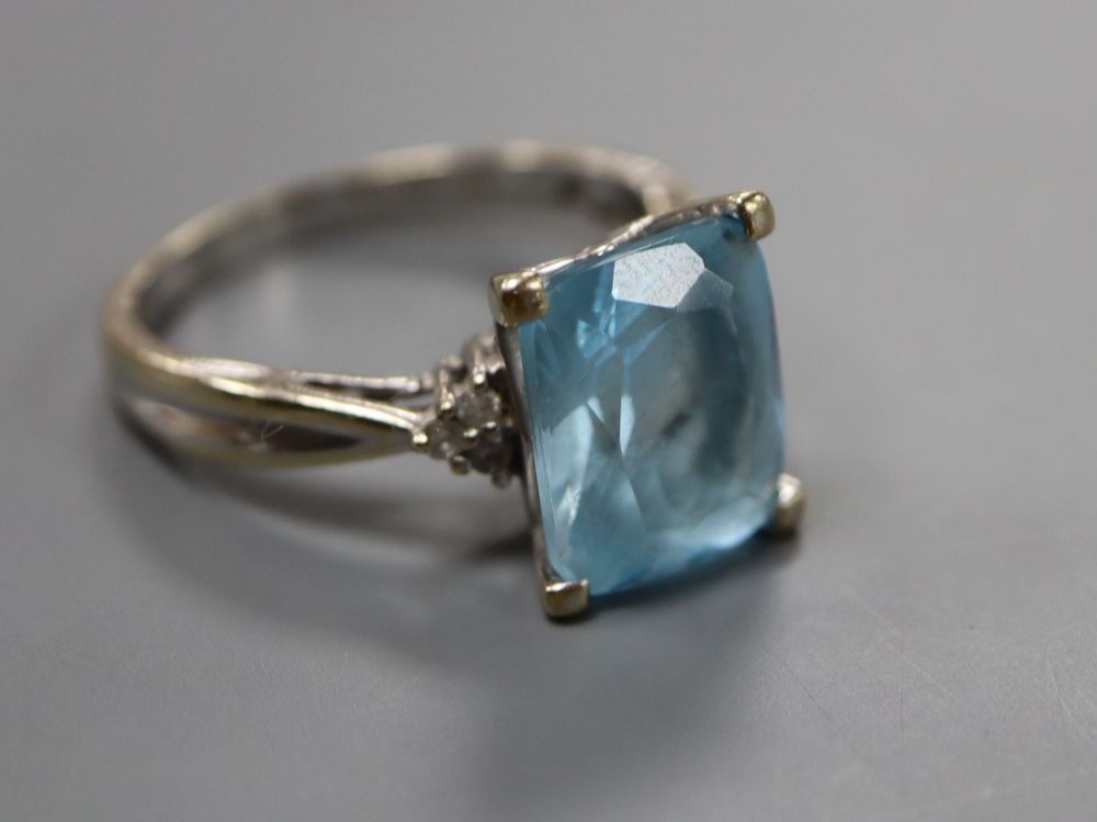 A modern 18ct white gold, blue topaz and diamond set dress ring, size S, gross 6.2 grams.